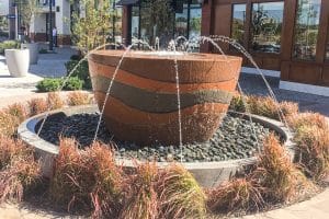 Concrete cup shaped water features with nozzles spraying water into its center
