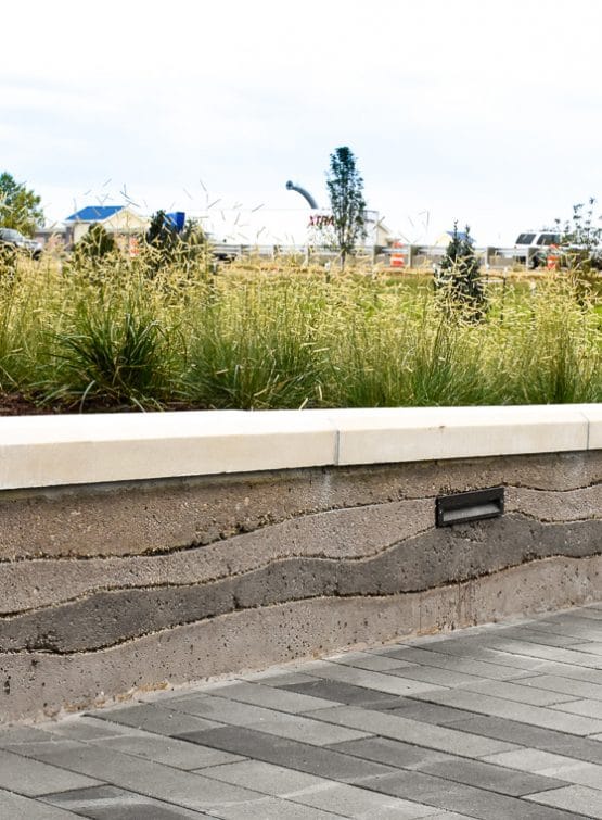 Sedimentary planter walls create a unique layered look around these planter beds.